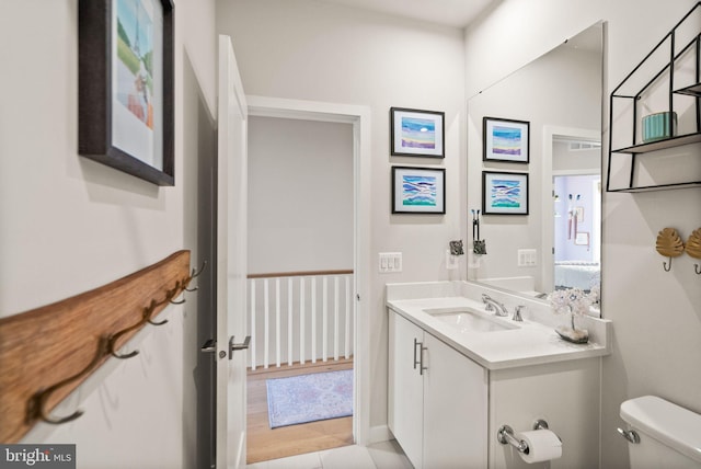 bathroom with toilet, tile patterned flooring, and vanity