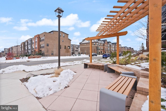 snow covered patio featuring a pergola