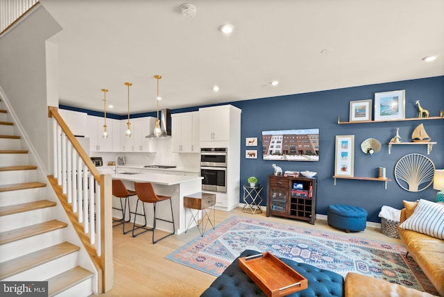 living room with sink and light hardwood / wood-style flooring