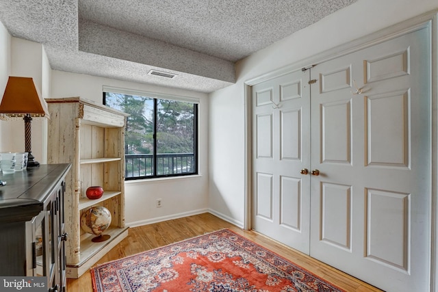 interior space with light wood-type flooring and a textured ceiling