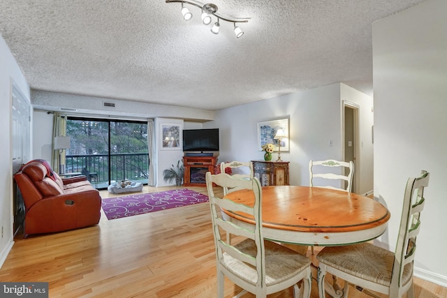 dining area featuring a textured ceiling and hardwood / wood-style flooring