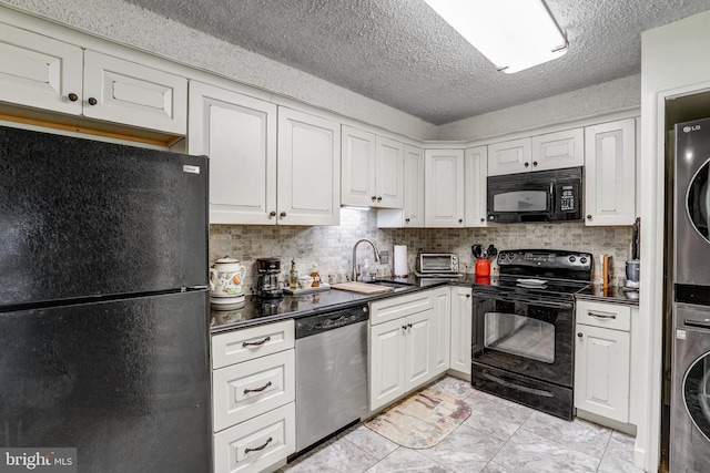 kitchen featuring white cabinets, black appliances, stacked washer and dryer, tasteful backsplash, and sink