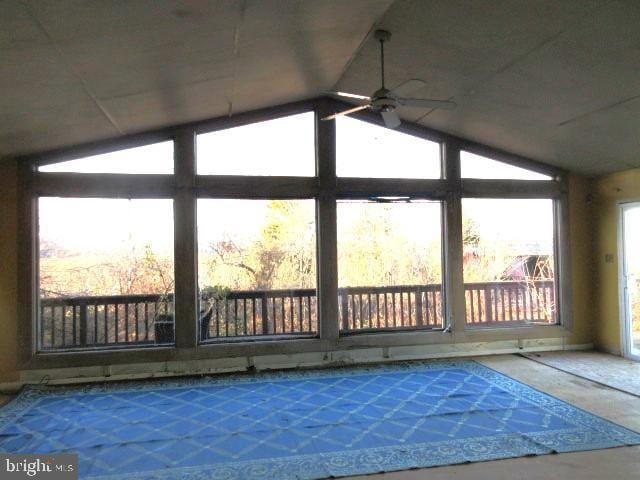 unfurnished sunroom featuring ceiling fan and vaulted ceiling