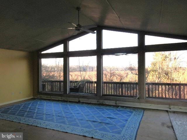 unfurnished sunroom with vaulted ceiling, ceiling fan, and plenty of natural light