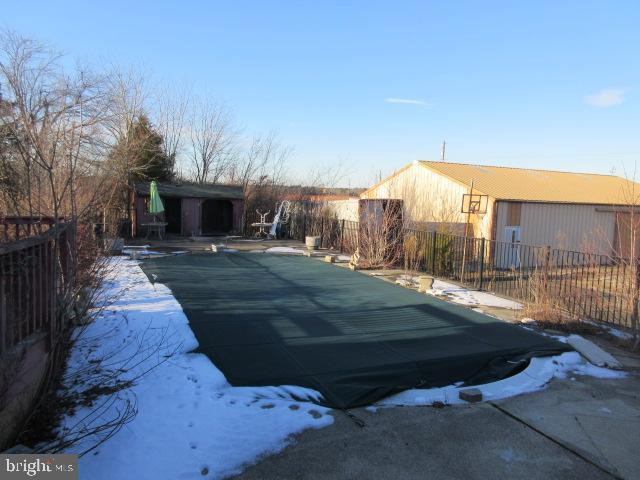 snow covered pool with a patio