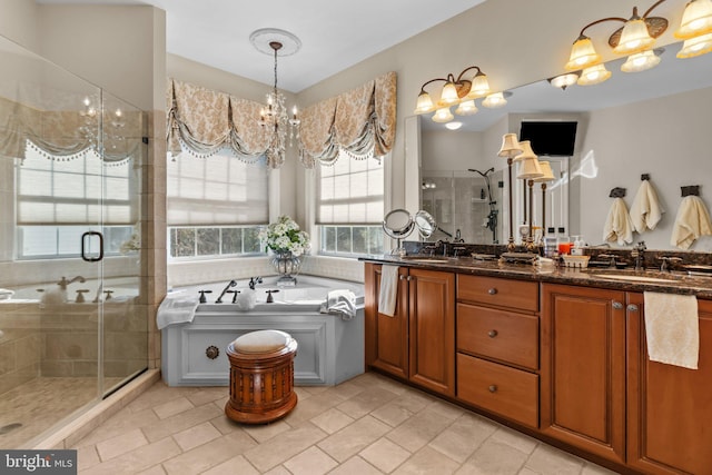 bathroom featuring a chandelier, vanity, and separate shower and tub