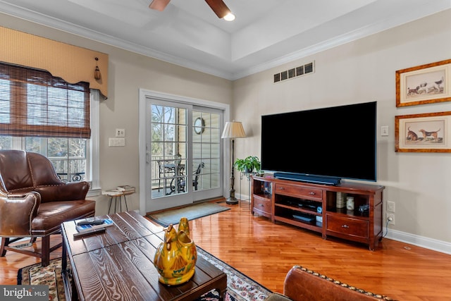 living room with crown molding, ceiling fan, plenty of natural light, and wood-type flooring