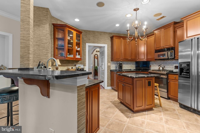 kitchen with pendant lighting, appliances with stainless steel finishes, a kitchen breakfast bar, a kitchen island, and kitchen peninsula