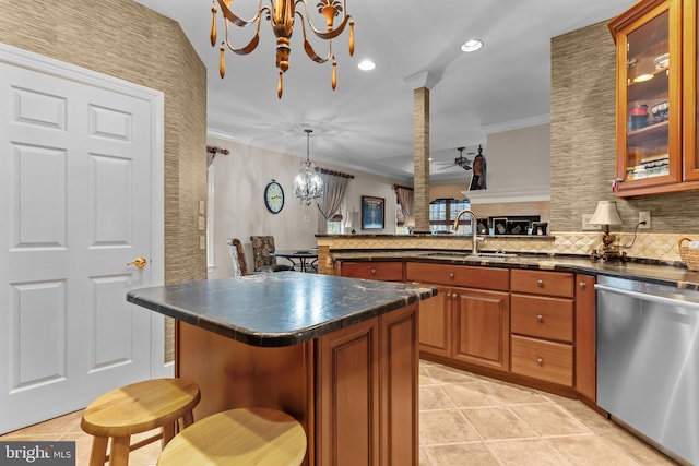 kitchen with sink, a breakfast bar area, hanging light fixtures, stainless steel dishwasher, and a kitchen island