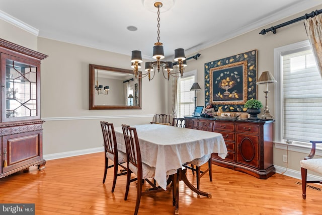 dining room featuring ornamental molding, light hardwood / wood-style floors, and a chandelier