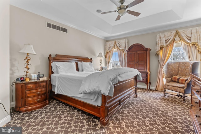 carpeted bedroom with crown molding, a raised ceiling, and ceiling fan