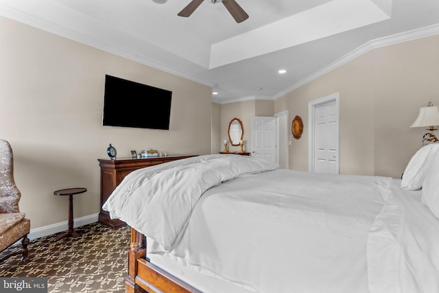 bedroom with ornamental molding, ceiling fan, and a tray ceiling