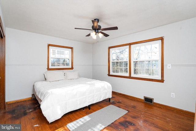 bedroom with ceiling fan, dark hardwood / wood-style floors, and multiple windows