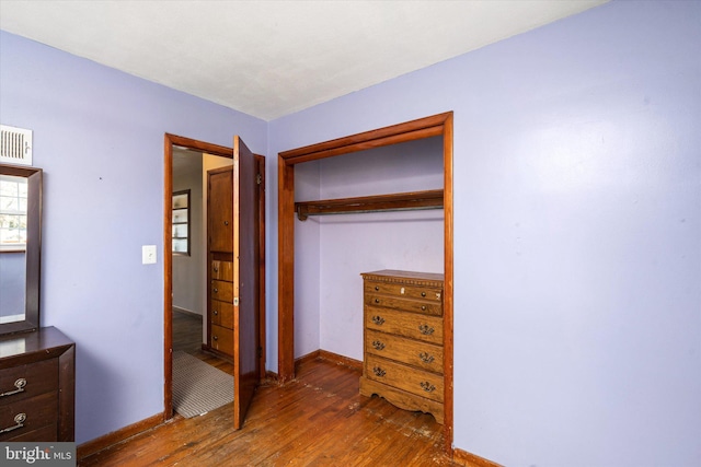 unfurnished bedroom with dark wood-type flooring and a closet