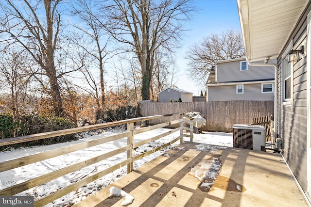 snow covered patio featuring central air condition unit