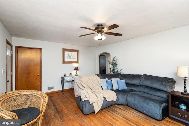 living room with dark hardwood / wood-style flooring and ceiling fan