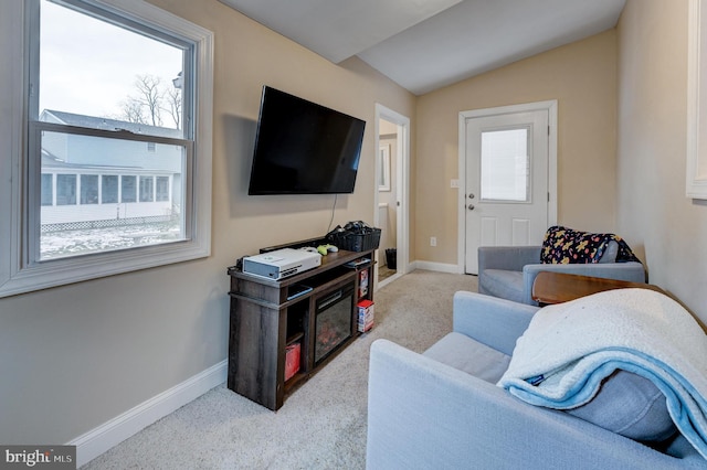 living room featuring vaulted ceiling, light carpet, and plenty of natural light