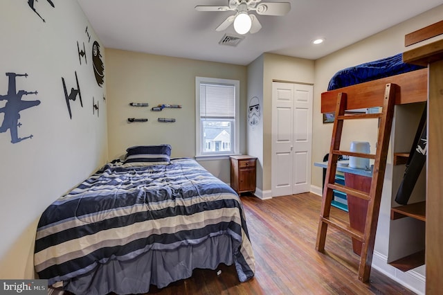 bedroom featuring hardwood / wood-style flooring, ceiling fan, and a closet