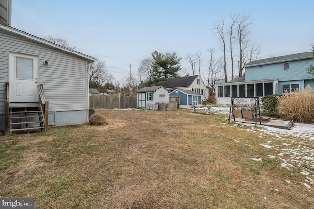 view of yard featuring a sunroom and a storage shed