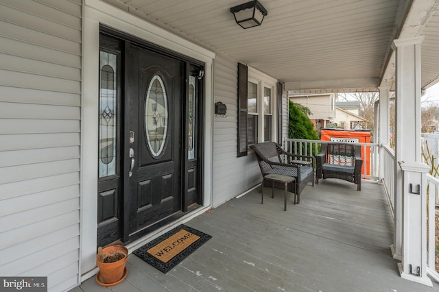 view of exterior entry featuring covered porch