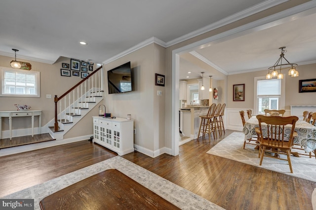 interior space featuring dark hardwood / wood-style floors, an inviting chandelier, crown molding, and plenty of natural light