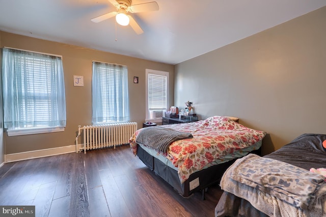 bedroom with ceiling fan, radiator heating unit, and dark hardwood / wood-style flooring