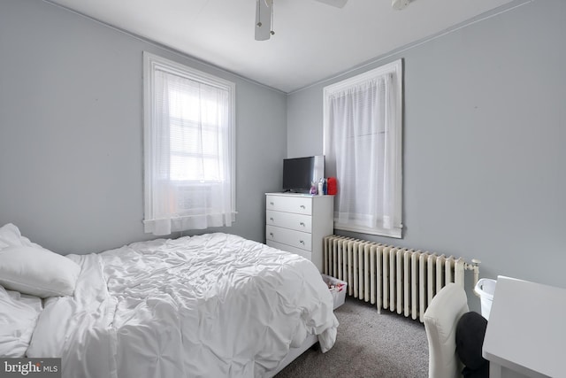 carpeted bedroom featuring radiator and ceiling fan