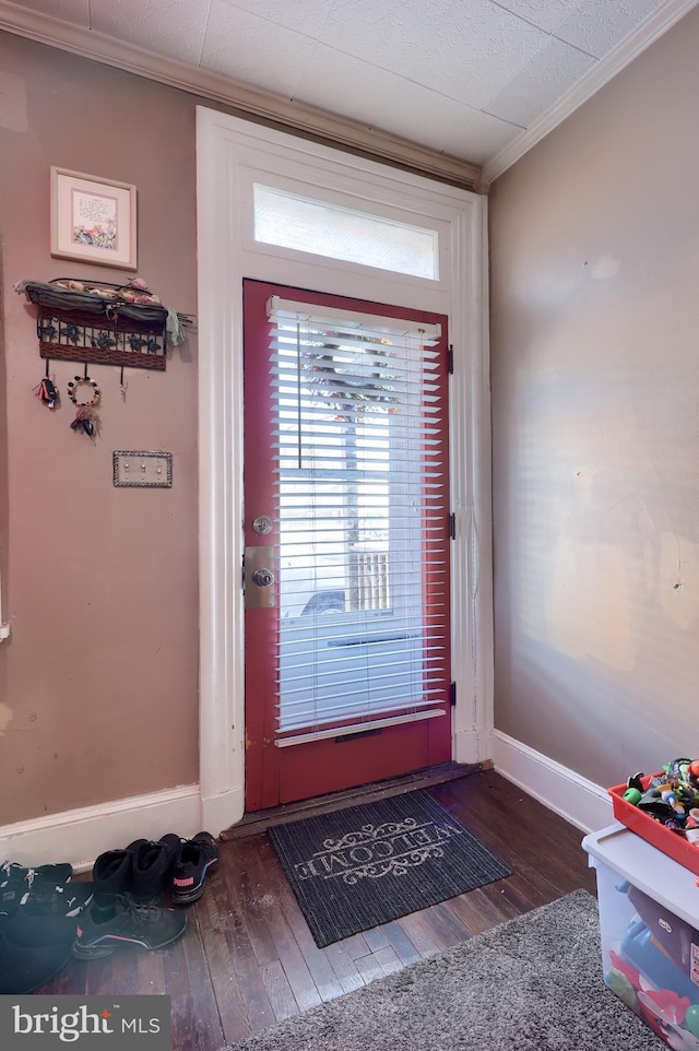 doorway featuring crown molding and dark hardwood / wood-style flooring