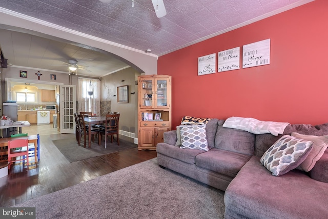 living room with crown molding, ceiling fan, and wood-type flooring