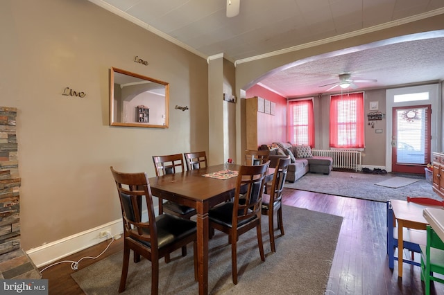 dining area featuring radiator, ornamental molding, hardwood / wood-style floors, and ceiling fan