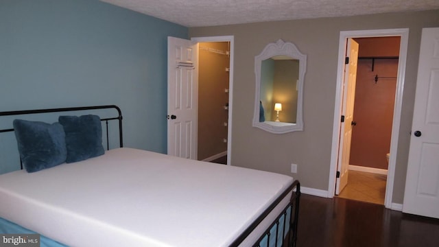 bedroom featuring a closet, a walk in closet, and a textured ceiling