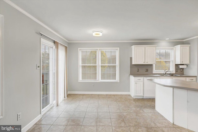 kitchen with white cabinets, plenty of natural light, crown molding, and sink