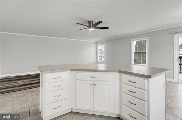 kitchen with a kitchen island, ornamental molding, and white cabinetry