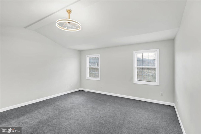 carpeted empty room featuring a healthy amount of sunlight and vaulted ceiling