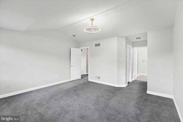 empty room with lofted ceiling and dark carpet