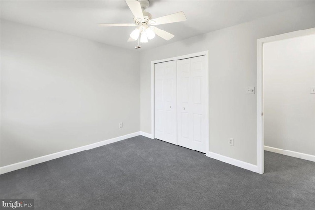 unfurnished bedroom featuring dark colored carpet, ceiling fan, and a closet