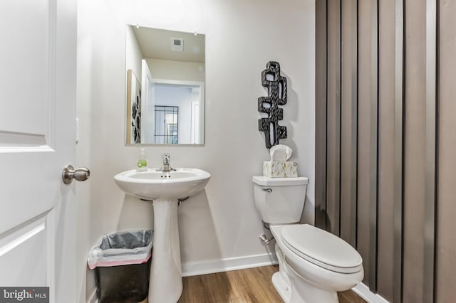 bathroom with toilet, hardwood / wood-style flooring, and sink