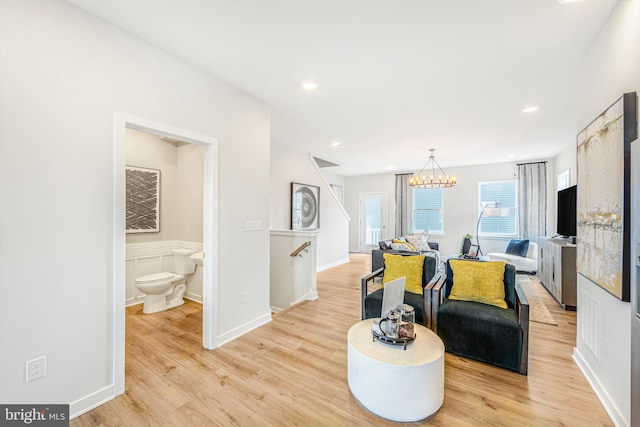 living room with a notable chandelier and light hardwood / wood-style flooring