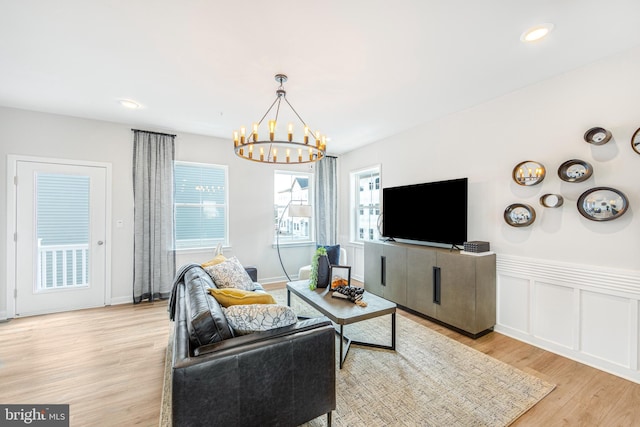 living room with light hardwood / wood-style floors and a chandelier