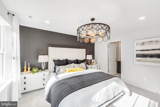 bedroom featuring light colored carpet and an inviting chandelier