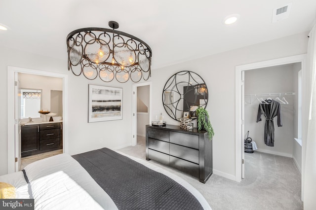 bedroom featuring a walk in closet, a closet, and light carpet