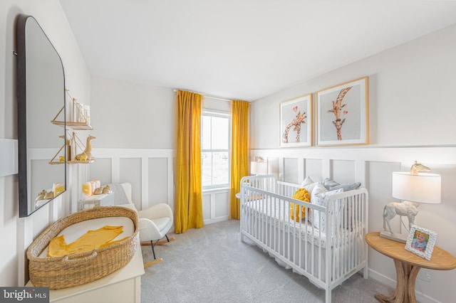 bedroom with a crib and light carpet