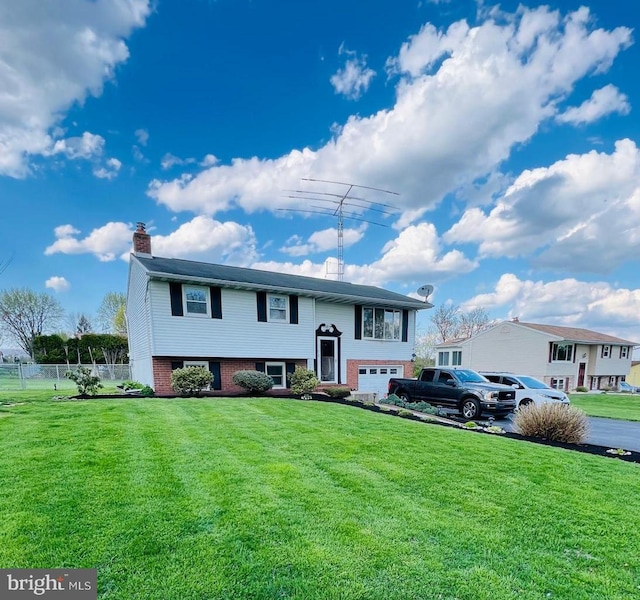 bi-level home with a front lawn and a garage