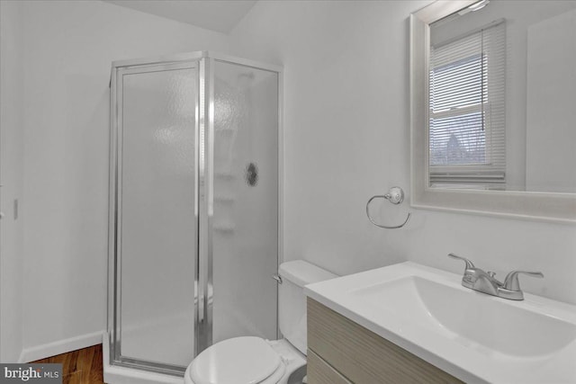 bathroom with toilet, vanity, a shower with door, and hardwood / wood-style floors