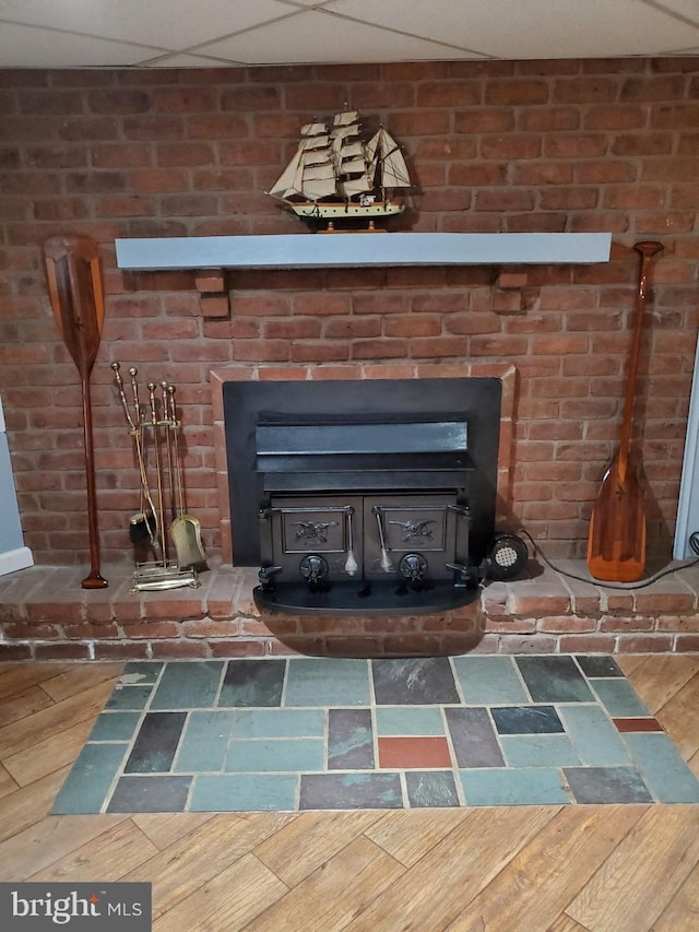 details featuring a wood stove and a drop ceiling