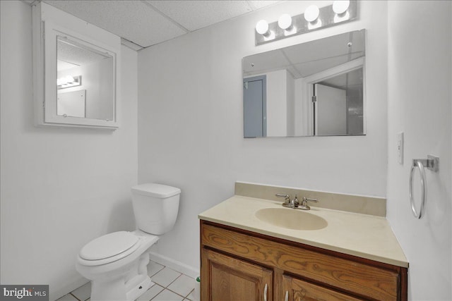 bathroom featuring toilet, tile patterned floors, a drop ceiling, and vanity