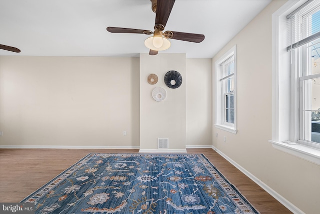 spare room featuring ceiling fan, a wealth of natural light, and hardwood / wood-style floors