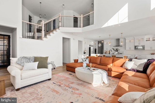 living room featuring light hardwood / wood-style flooring and a high ceiling