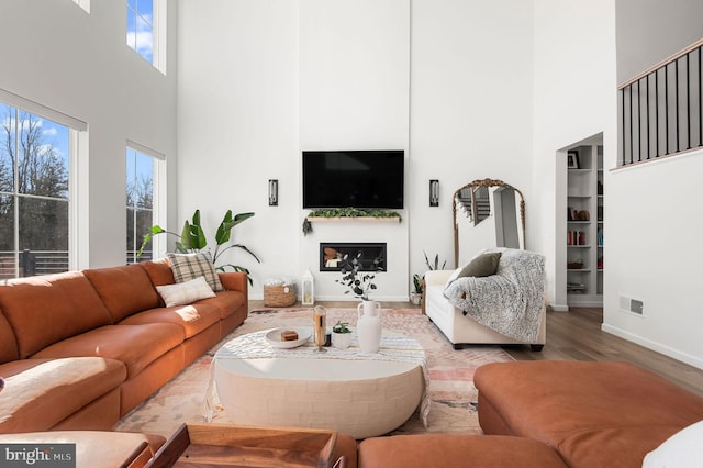 living room featuring light hardwood / wood-style floors and a towering ceiling