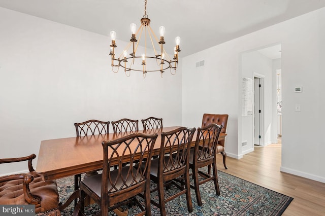 dining space with a chandelier and wood-type flooring